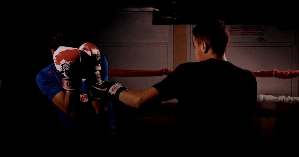cover article - plugins paiement Shopify PrestaShop - man in black t-shirt and red boxing gloves