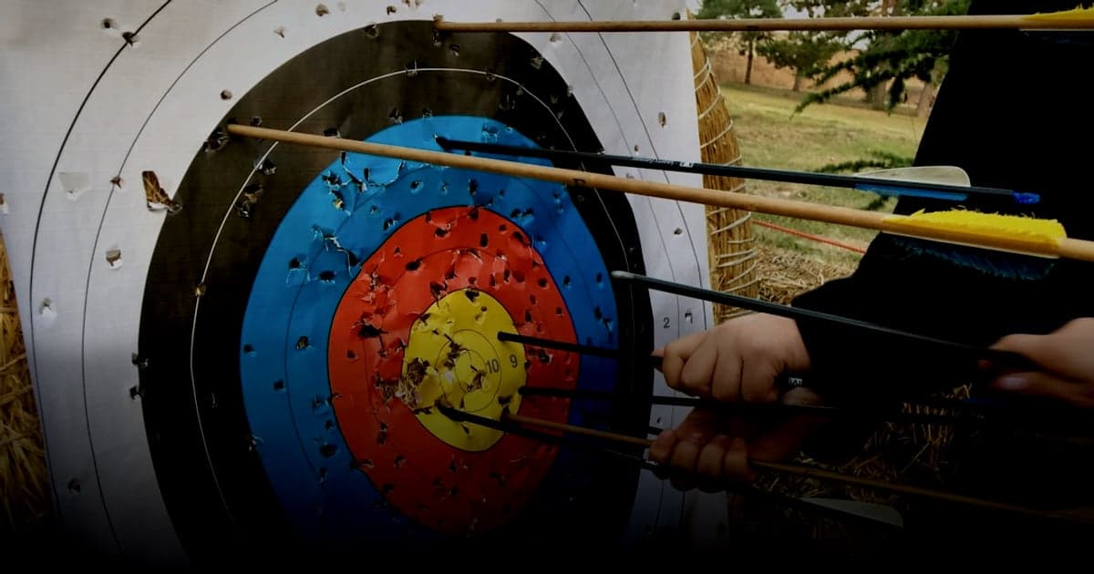 cover article - solutions paiement ligne - a group of people holding arrows in front of a target