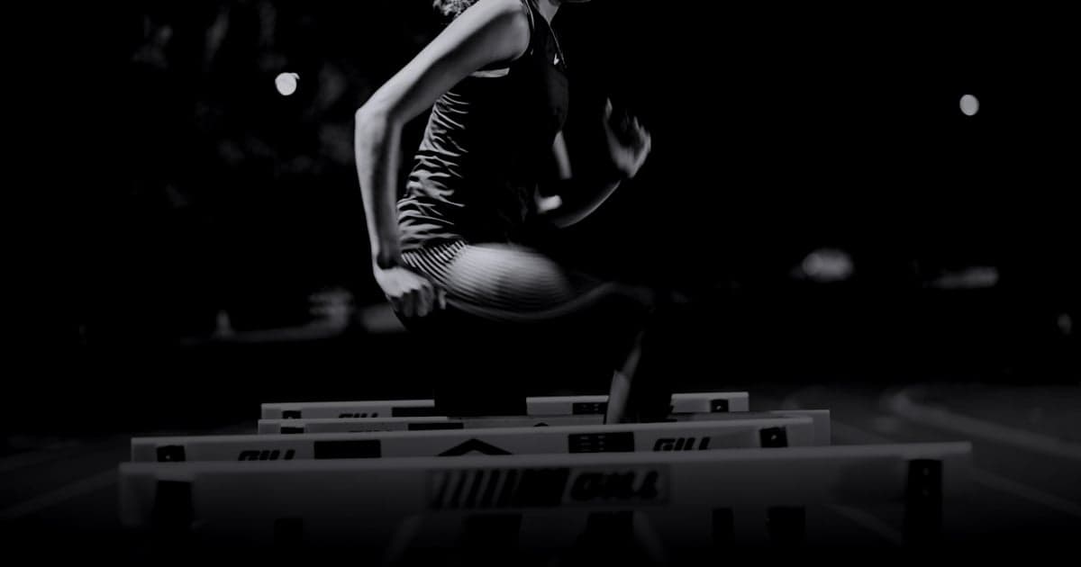 cover article - meilleures IA pour la rédaction web - A woman is jumping over a hurdle on a track
